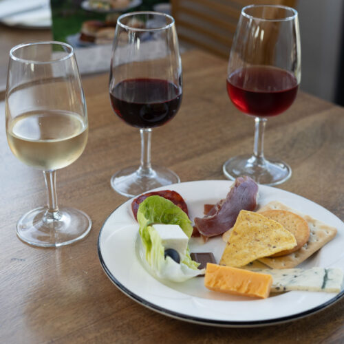Wine and Cheese tasting with 3 bottles of wine and a plate of cheese and crackers